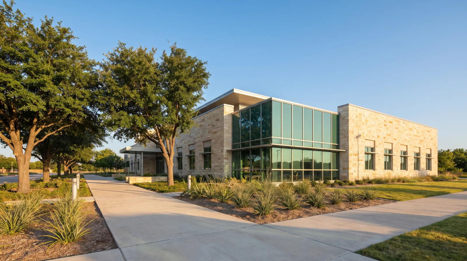 Modern stone and glass government building with a landscaped walkway in daylight
